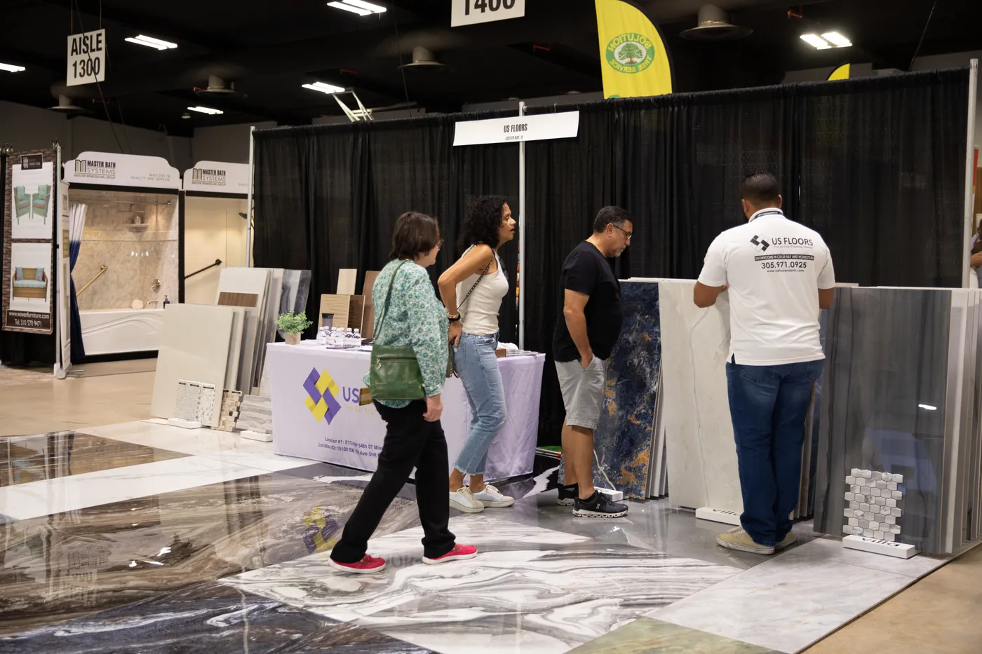 Visitors examining stone and tile slabs at the US Floors booth