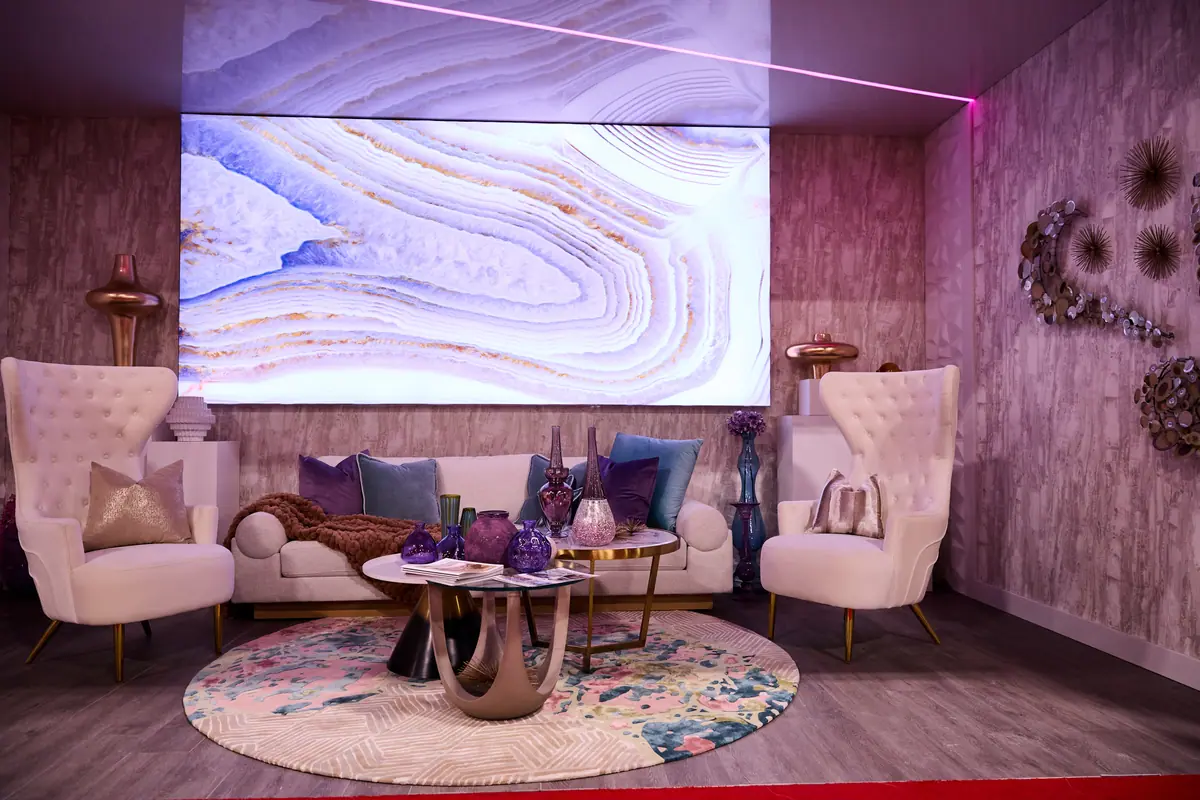 Dramatic violet-lit living room design trend display with tufted chairs, sofa, and LED art wall