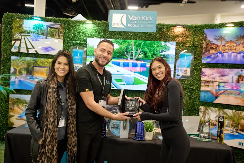 Van Kirk and Sons Pools and Spas team holds an award at their home show booth