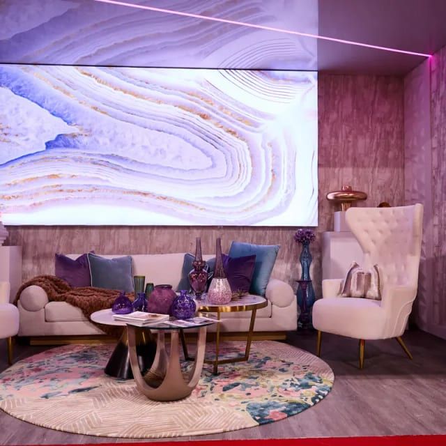 Glamorous purple-themed living room exhibit with large backlit agate art panel and velvet accents