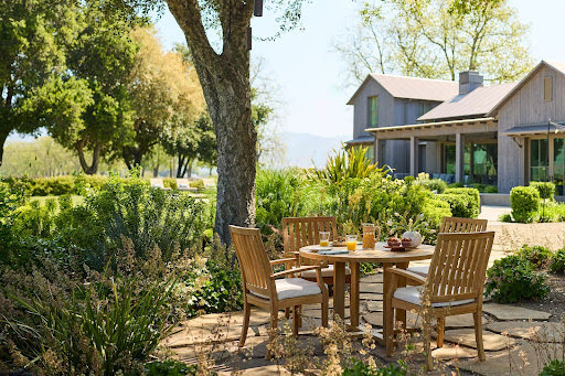 Outdoor patio dining set surrounded by greenery featured at the Home Design and Remodeling Show.