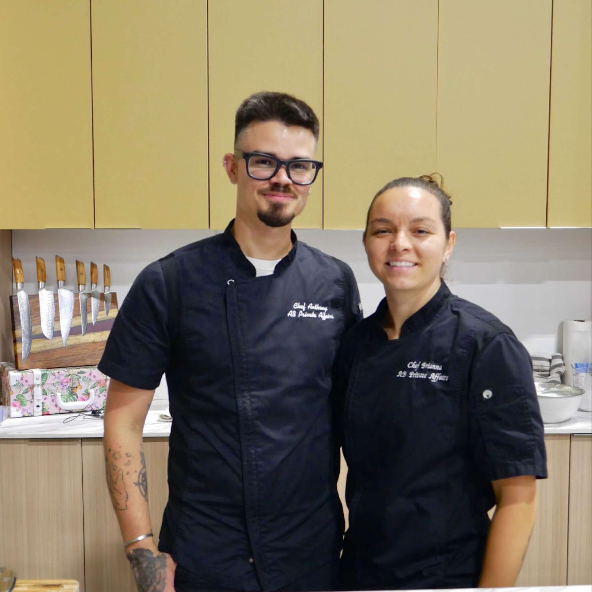 Two chefs posing together after a cooking demonstration at the Home Design and Remodeling Show.