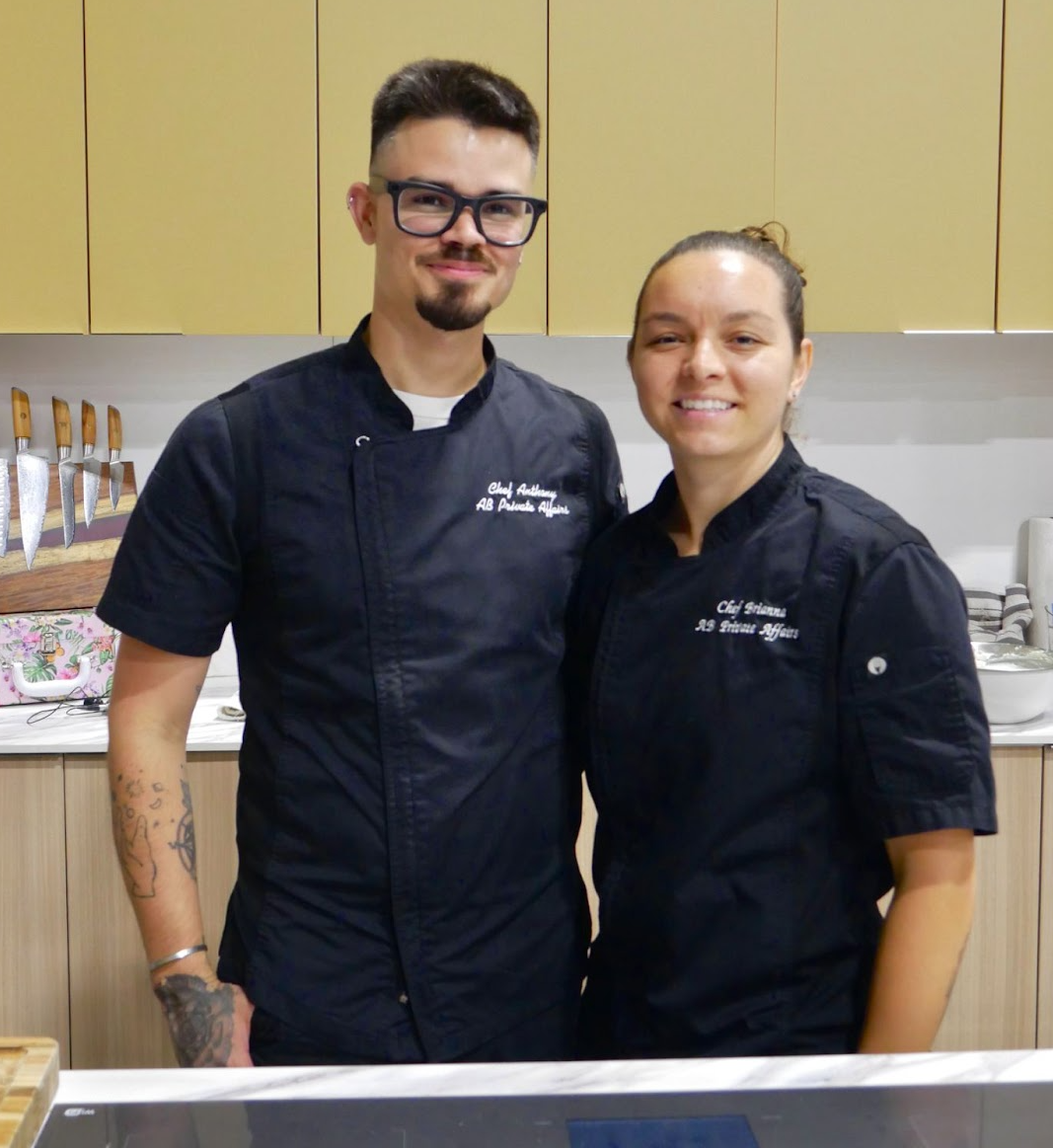 Two chefs posing together after a cooking demonstration at the Home Design and Remodeling Show.